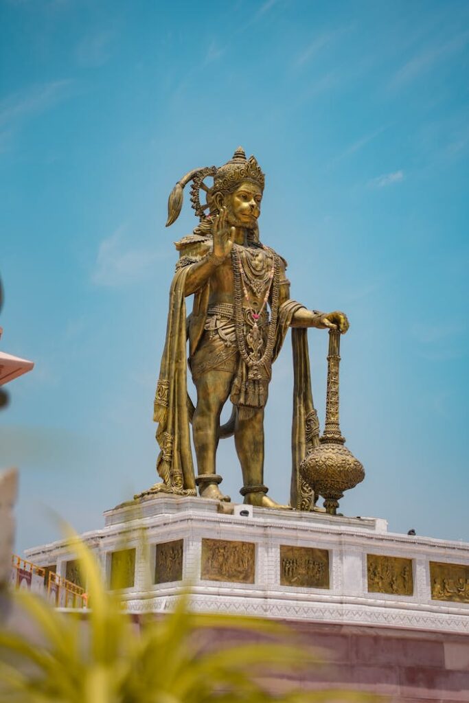 Stunning low angle view of the Hanuman statue in Ahmedabad, showcasing ornate details against a clear blue sky.