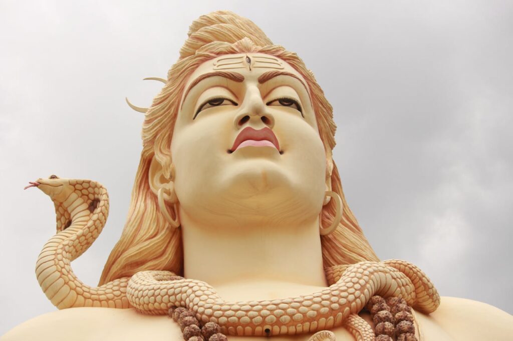 Close-up of a towering Shiva statue with a cobra, representing Hindu spirituality and artistry.